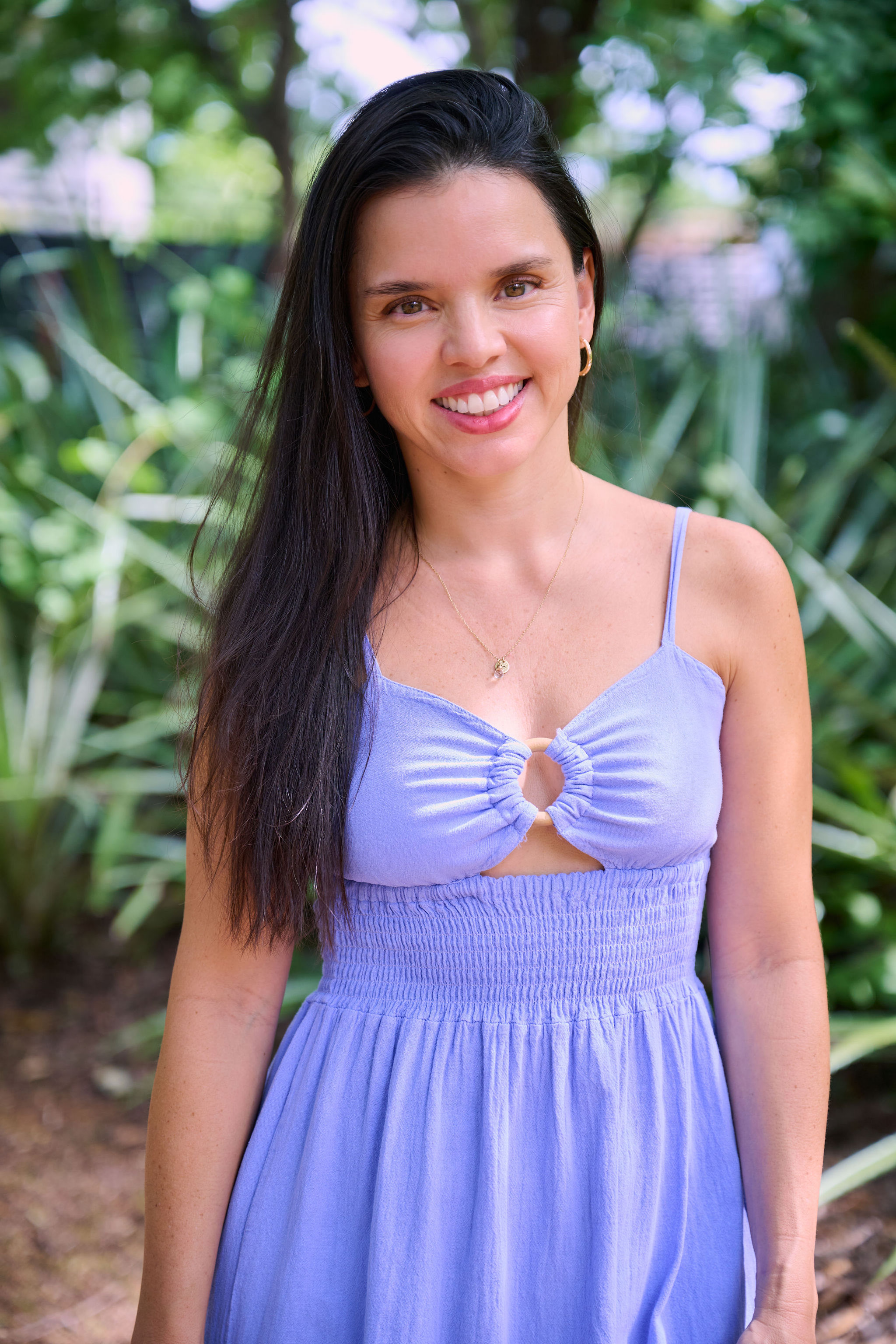Paola Castro smiling in a garden portrait