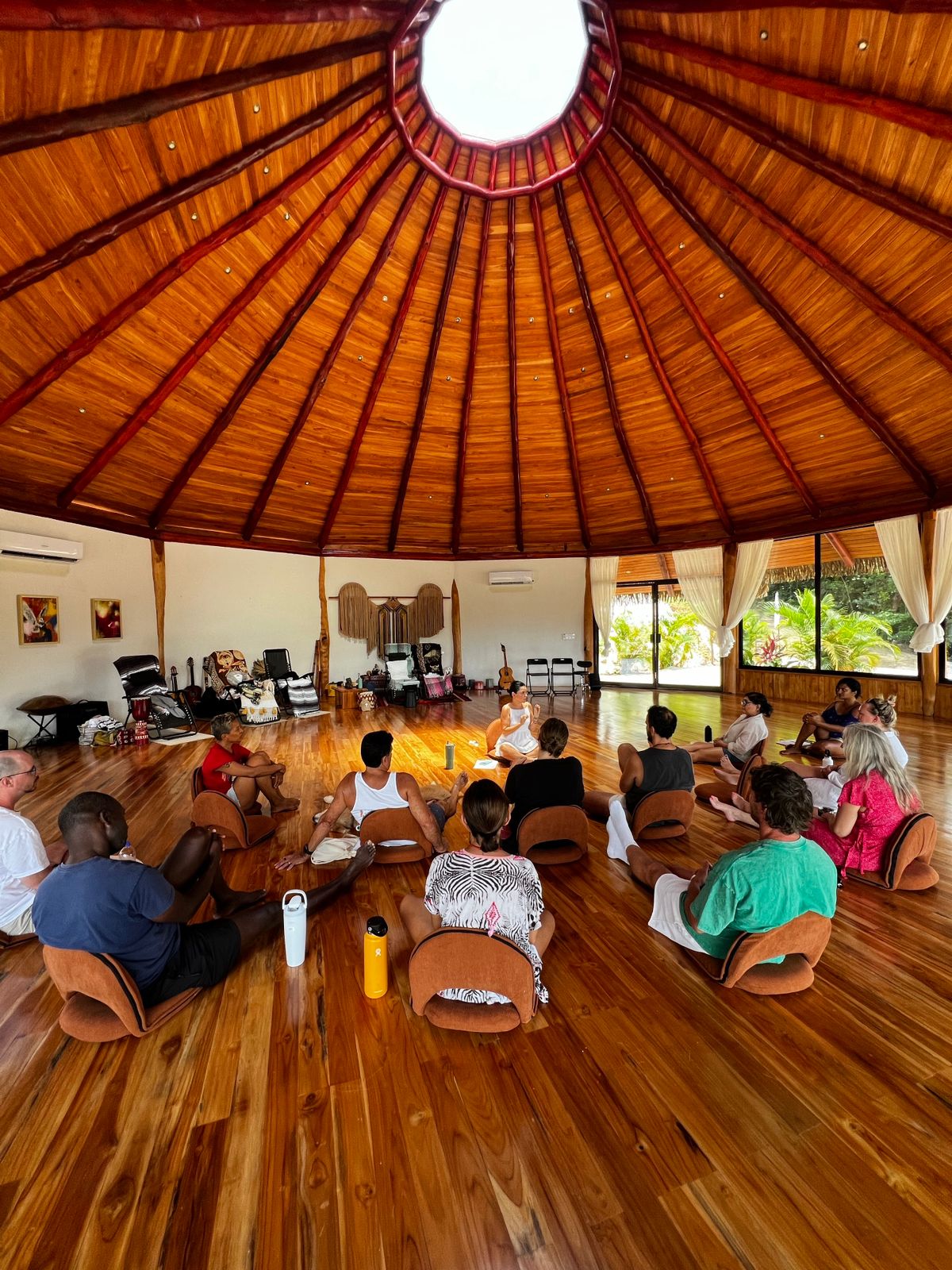Paola facilitating a group circle in a wooden pavilion