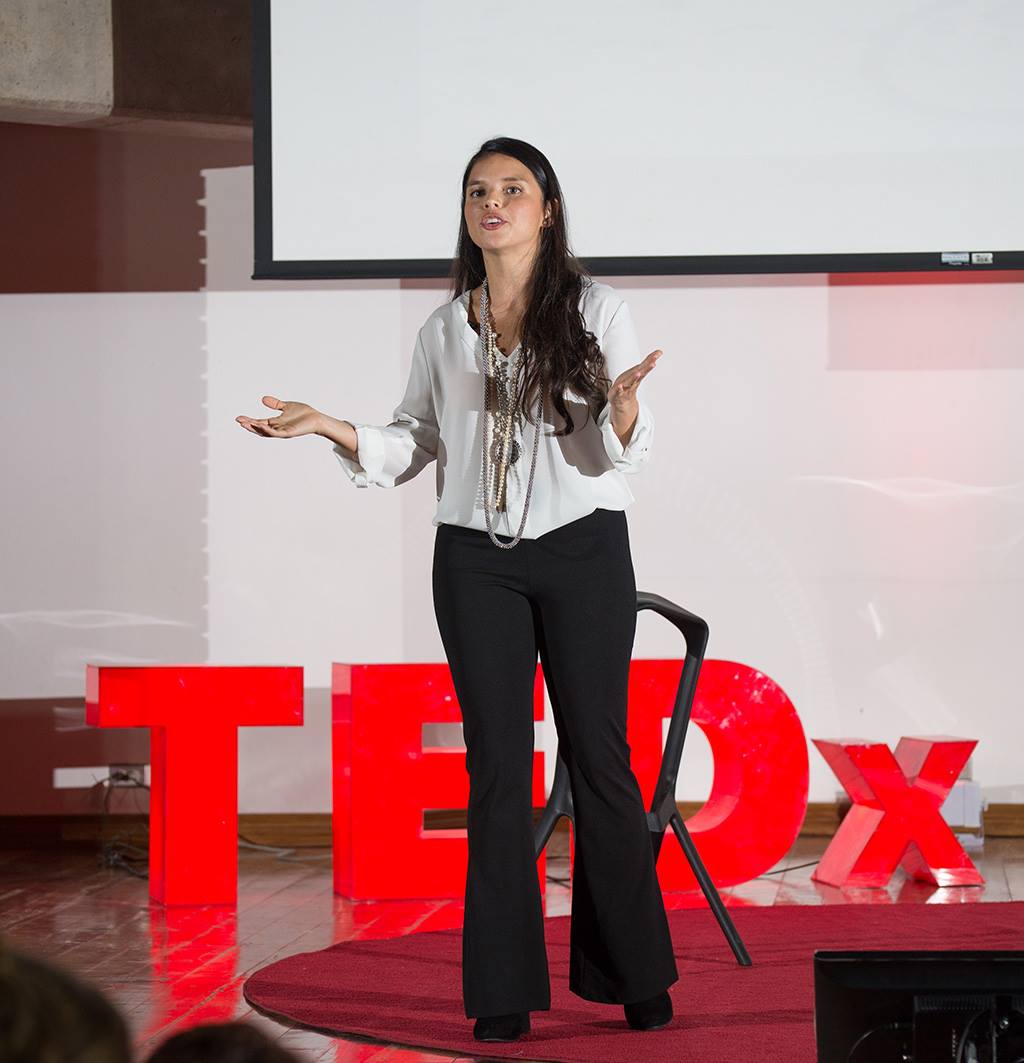 Paola speaking on a TEDx stage